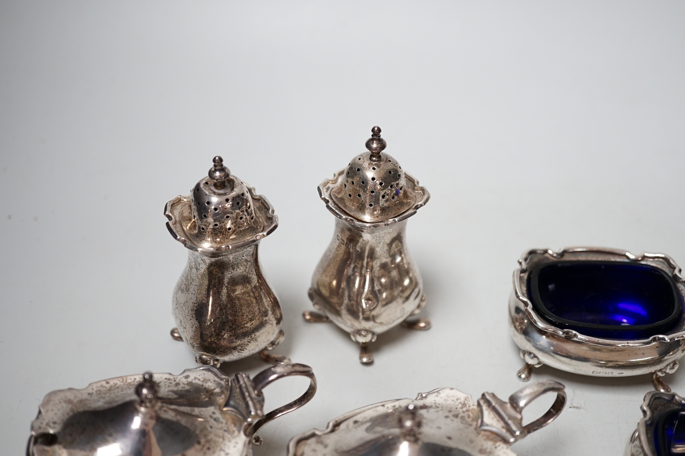 Two four piece silver cruet sets.